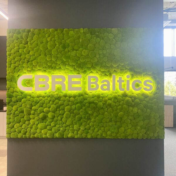 CBRE Baltics kontori mätassamblikust sein valgustatud logoga. Akustiline sein.