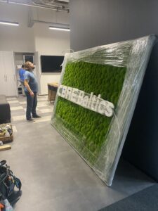 CBRE Baltics kontori mätassamblikust sein valgustatud logoga. Akustiline sein.