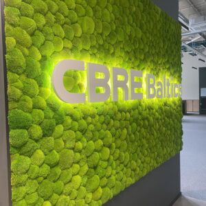 CBRE Baltics kontori mätassamblikust sein valgustatud logoga. Akustiline sein.