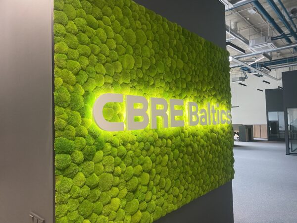 CBRE Baltics kontori mätassamblikust sein valgustatud logoga. Akustiline sein.