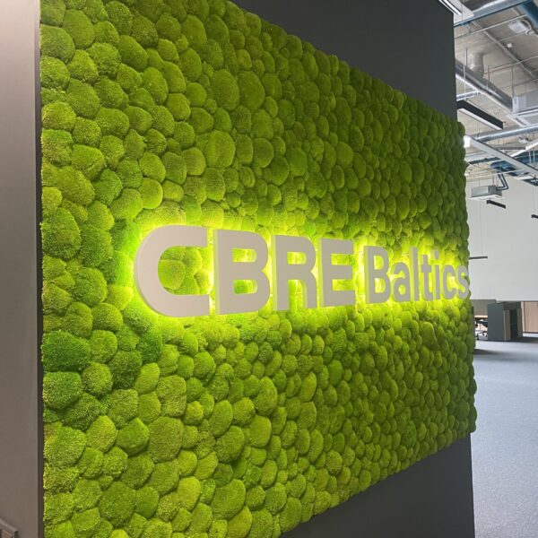 CBRE Baltics kontori mätassamblikust sein valgustatud logoga. Akustiline sein.